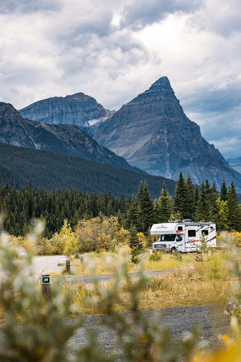 A white recreational vehicle parked at a mountain campground.